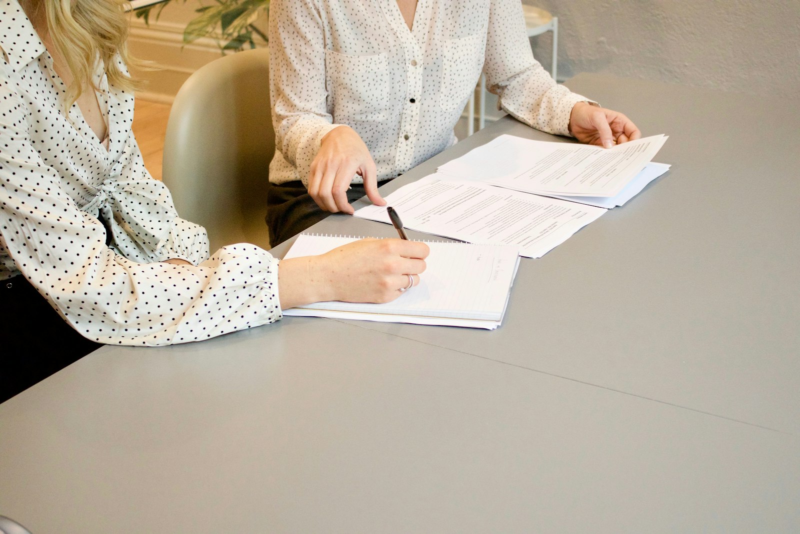 AI Act : ce qui change vraiment pour une PME après l'Omnibus 3 Deux femmes à une table, l'une signant une charte d'usage de l'IA imprimée