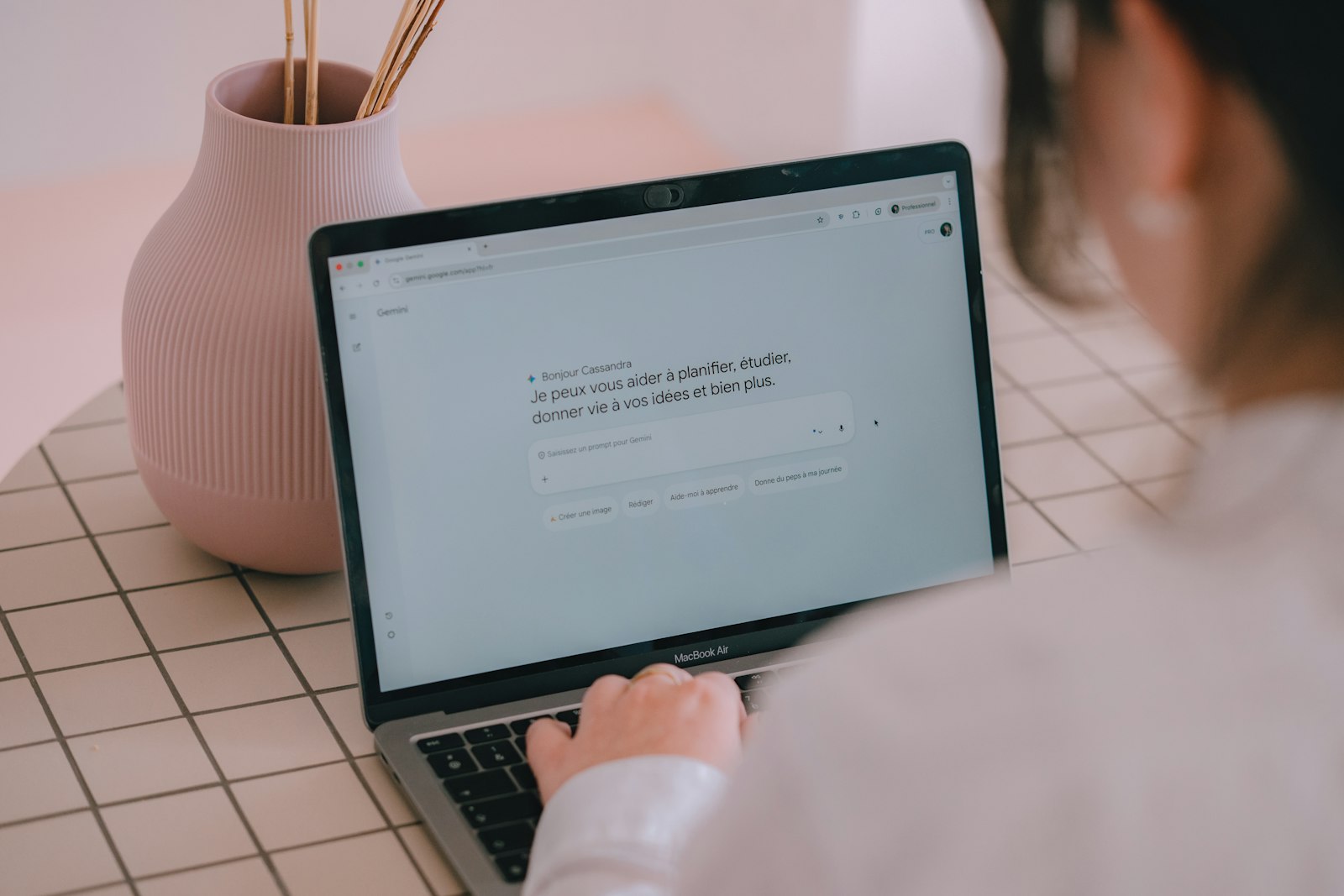 Écran de Gemini ouvert sur une zone de prompt en français, mains sur le clavier d'un ordinateur portable